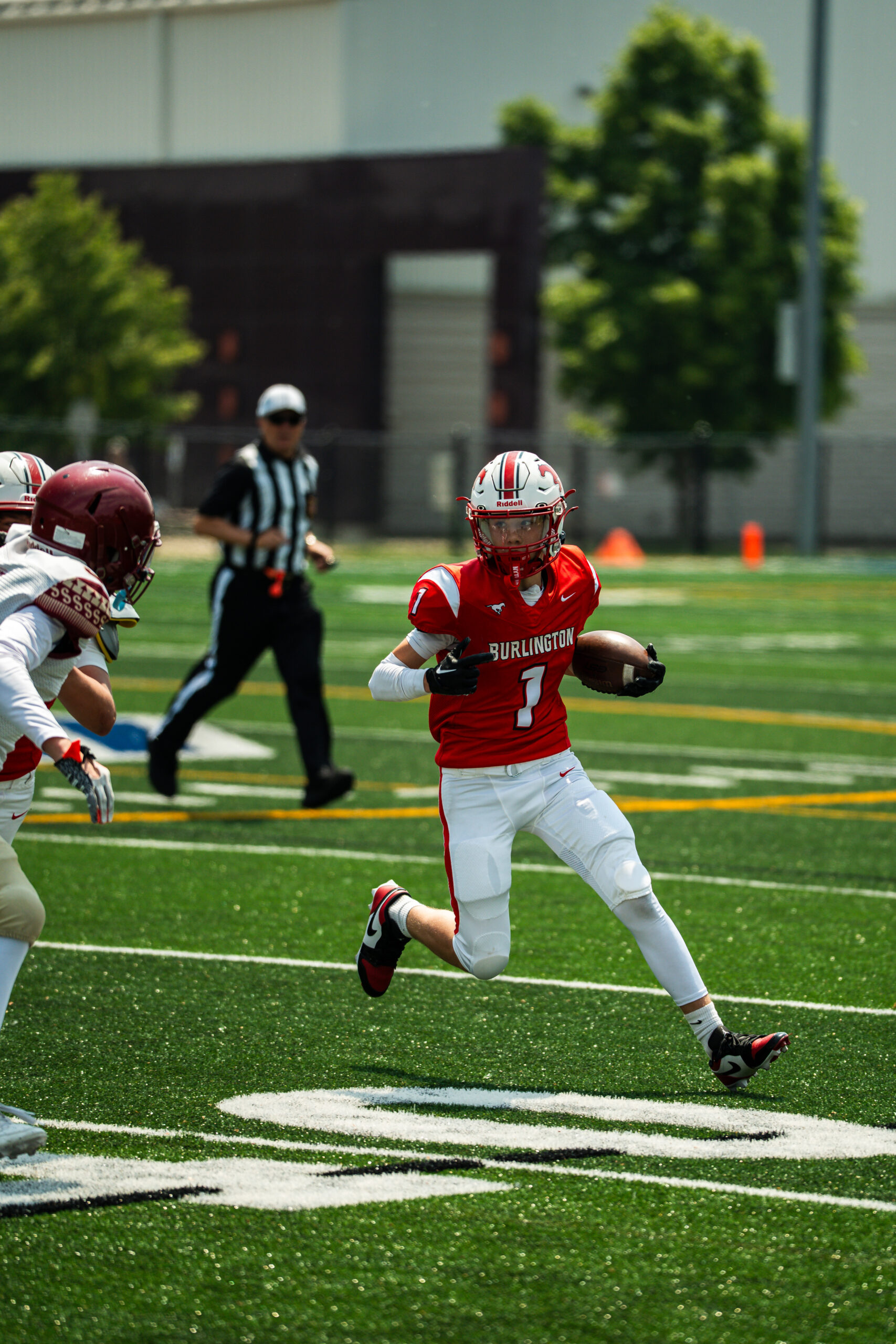 A Burlington player breaks into the open field during a tackle football game.